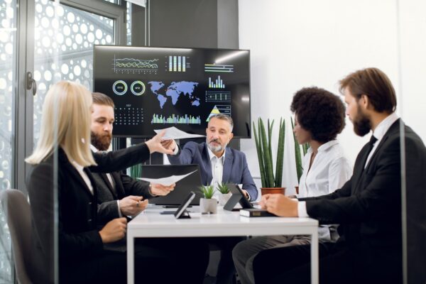 Diverse group of multiracial business people in the conference room with big TV screen, cooperating