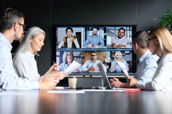 Global corporate video call in meeting room with diverse multiethnic people.