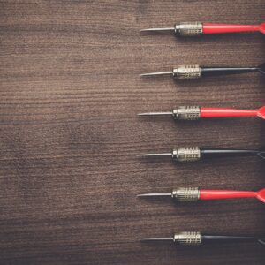 red and black darts on wooden background