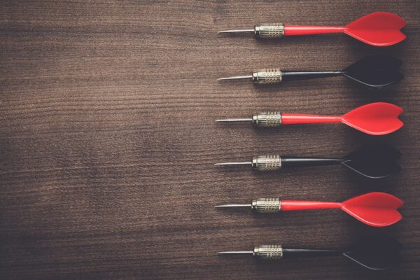 red and black darts on wooden background