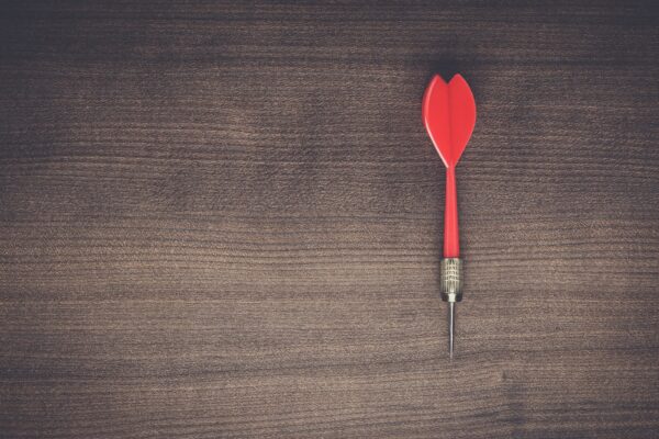 red dart on wooden background